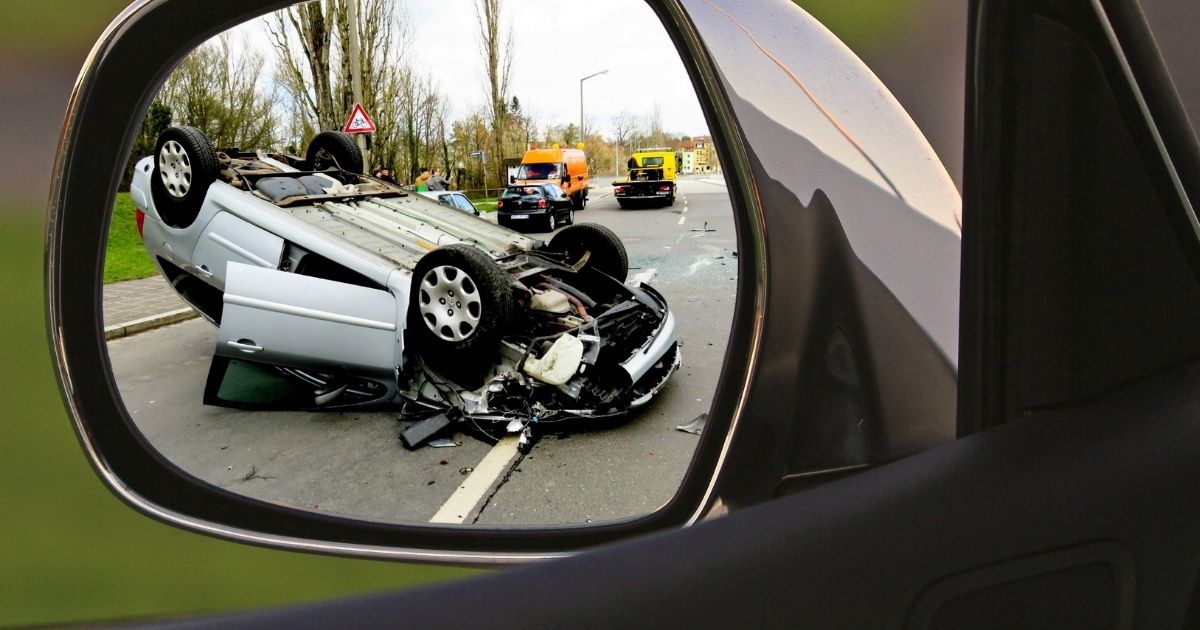 Accident de circulation avec voiture retournée vu dans le rétroviseur