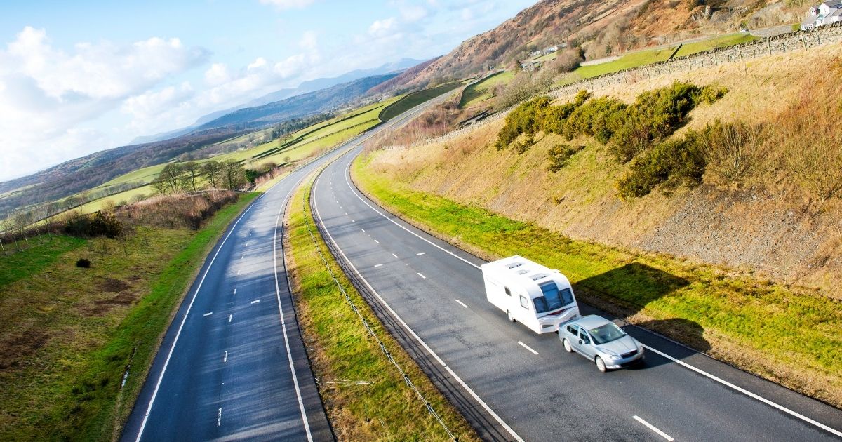 Autoroute de montagne avec caravane tractée au loin